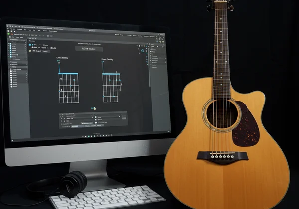 شاشة جيتار افتراضي بجانب جيتار صوتي حقيقي